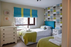 Dormitorio infantil con 2 camas y ventana en Stylish family home in desirable Penylan + Parking, en Cardiff