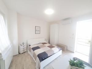 Habitación blanca con cama y ventana en Mini Suite Valentino, en Casale Monferrato