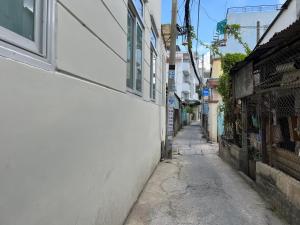 an alley way with a white wall and a building at The Lucky House 1 in Ho Chi Minh City