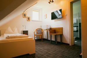 a bedroom with a bed and a tv on the wall at Motorradhotel Gailtaler Hof in Kötschach