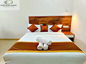 a bed with two rolled up towels on it at Oryzaland Holiday Villa in Munnar