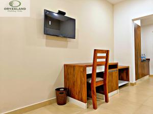 a room with a desk and a television on the wall at Oryzaland Holiday Villa in Munnar