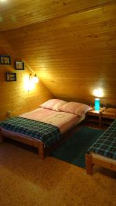 a bedroom with a bed in a wooden room at Cztery Pory Roku - Dom in Lutowiska