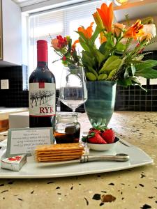 a plate with a bottle of wine and a glass at Gray Cottage in Strand +6 photos