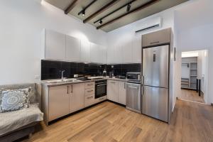a kitchen with white cabinets and a stainless steel refrigerator at Kimia Luxury Apartments in Kolymbia