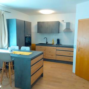 una cucina con bancone blu e armadi in legno di Gemütliche Wohnung mit Küche und Netflix a Klingenthal