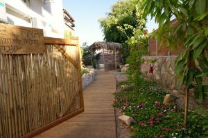 przejście w ogrodzie z płotem i kwiatami w obiekcie RAKEFET - Traveler's House - EILAT w Ejlat