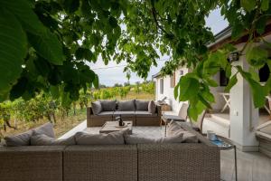 a patio with a couch and a table at d.Five Vineyard & Retreat Kőröshegy in Kőröshegy