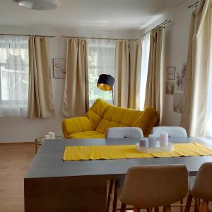 un soggiorno con divano giallo e tavolo di Gemütliche Wohnung mit Küche und Netflix a Klingenthal