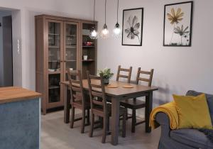 a dining room table and chairs in a living room at Apartament w parku in Oświęcim