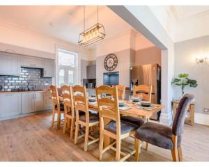 a kitchen and dining room with a table and chairs at Victoria House in Southport