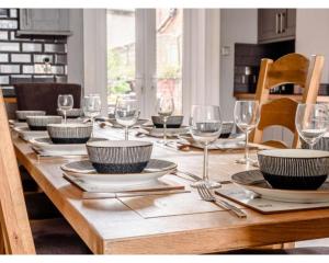 - une table en bois avec des assiettes et des verres à vin dans l'établissement Victoria House, à Southport
