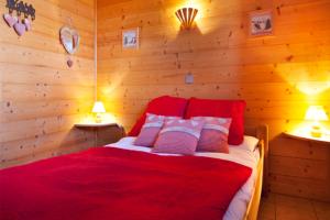 a bedroom with a red bed with two lamps at Chalet Juliet 10 people in Montalbert