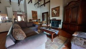 ein Wohnzimmer mit einem Sofa und einem Tisch in der Unterkunft Aviemore Lodge in Dullstroom