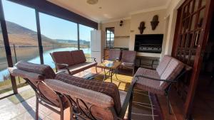 a living room with chairs and a view of the water at Aviemore Lodge in Dullstroom