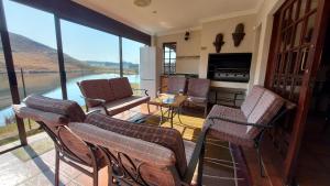 ein Wohnzimmer mit Stühlen und Blick auf das Wasser in der Unterkunft Aviemore Lodge in Dullstroom