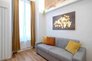 a living room with a couch and a painting on the wall at Milano City Apartments - Duomo Brera - Elegant Suite in Design District in Milan