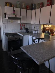 a kitchen with a counter and a stove and a table at The Farmhouse in Okahandja