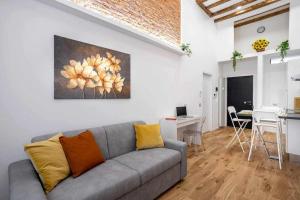 een woonkamer met een grijze bank en een keuken bij Milano City Apartments - Duomo Brera - Elegant Suite in Design District in Milaan