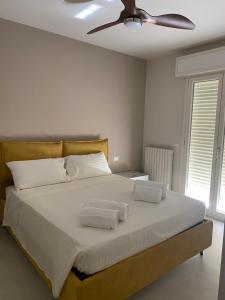 een slaapkamer met een groot wit bed en een plafondventilator bij Cà del Faro in Fano