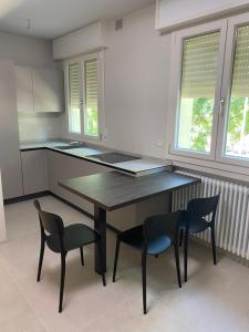 een keuken met een houten tafel en 2 stoelen bij Cà del Faro in Fano