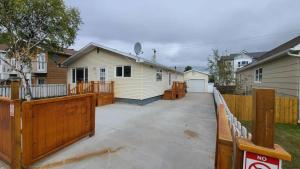 a house with a wooden fence and a driveway at YK Aurora in Yellowknife