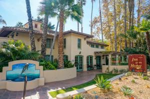 a house with palm trees in front of it at Inn by the Harbor in Santa Barbara