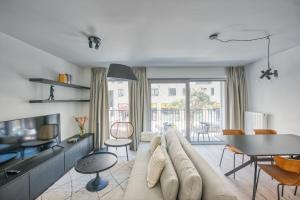 a living room with a large couch and a table at Cosy Seaside Apartments in Ostend