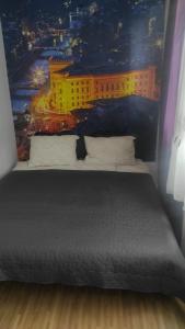 een slaapkamer met een bed en een schilderij van een stad bij Grbavica in Sarajevo