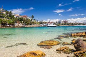 uma vista para uma praia com pedras na água em The Ryokan - Zen em Sidney