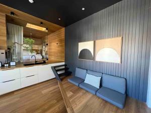 a living room with a blue couch and a kitchen at The Ryokan - Zen in Sydney