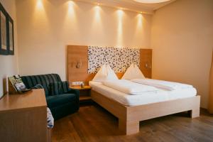 A bed or beds in a room at Motorradhotel Gailtaler Hof