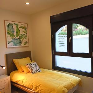 een slaapkamer met een bed en een raam bij Casa del Sol, la Paloma beach apartment with pool in Manilva