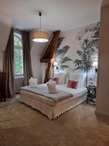 a bedroom with a large white bed in a room at Manoir d'Hautegente in Coly