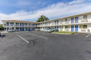 un gran edificio con coches estacionados en un estacionamiento en Motel 6-Santa Clara, CA, en Santa Clara