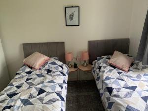 two beds sitting next to each other in a bedroom at Muirfad Cottage in Palnure
