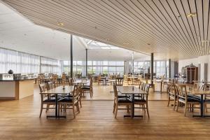una sala da pranzo con tavoli, sedie e finestre di Best Western Eurostop Orebro a Örebro