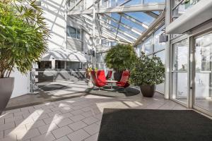 a greenhouse with red chairs and plants in it at Best Western Eurostop Orebro in Örebro