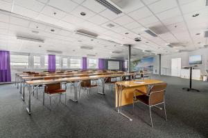 a large room with tables and chairs and purple curtains at Best Western Eurostop Orebro in Örebro