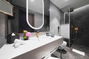 a bathroom with a sink and a toilet and a mirror at Radisson Collection Hotel, Vadistanbul in Istanbul