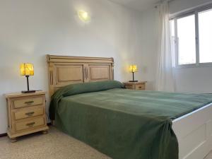 sypialnia z zielonym łóżkiem i 2 szafkami nocnymi w obiekcie Apartamento Fuengirola beach w mieście Fuengirola