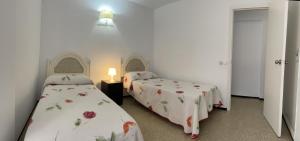 een kamer met twee bedden en een lamp erin bij Apartamento Fuengirola beach in Fuengirola