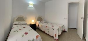 pokój z 2 łóżkami i lampką w obiekcie Apartamento Fuengirola beach w mieście Fuengirola