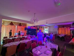 a room filled with tables and chairs with purple lighting at The Grove Hotel in Bournemouth
