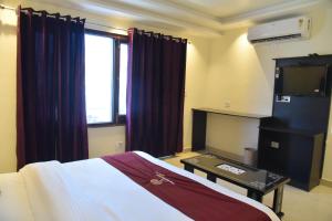 a hotel room with a bed and a window at The Divine Oak Golden Leaf in Katra