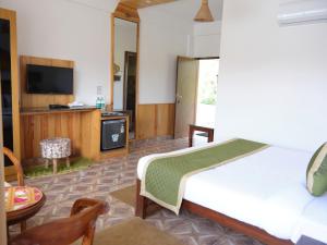 Habitación de hotel con cama y TV en Veda5 Wellness Retreat & Spa, en Old Goa