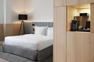 een slaapkamer met een bed met een witte sprei bij Radisson Blu Hotel, Hasselt in Hasselt