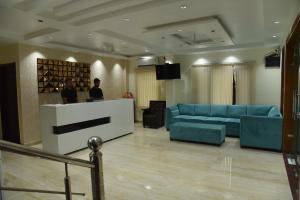a living room with a blue couch and a counter at The Divine Oak Golden Leaf in Katra