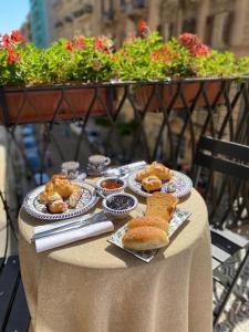 a table with plates of pastries and bread on it at Ballaro' Hotel - Budget Room in Palermo