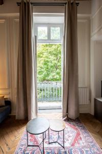 a living room with two tables and a window at Le Chavannes -Ecrin élégant & Cosy - Pentes de la Croix Rousse in Lyon